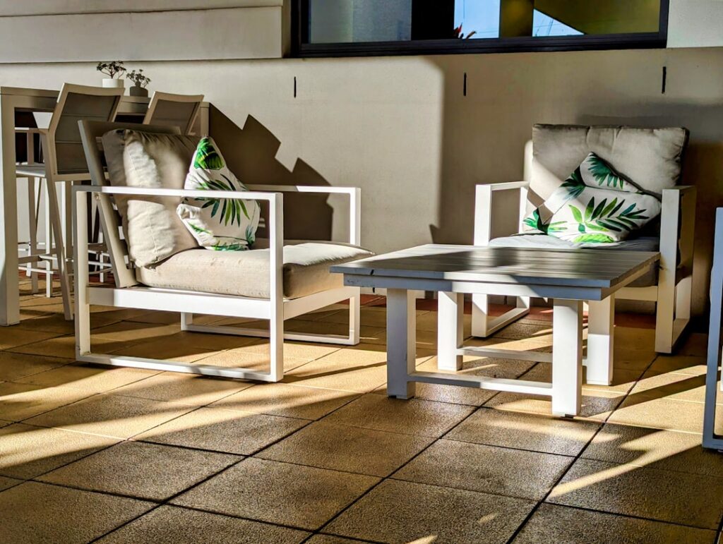 Two people relaxing on a backyard patio with a mix of flagstone and concrete flooring options.